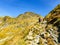 Hikers climb to Capra Lake, Fagaras Mountains, Romania.