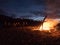 Hikers crowd around a beach bonfire at the end of the heaphy trail on New Zealands West Coast.