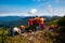 Hikers, friends stand, embracing on a mountain top