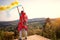 Hikers girl with hands up holding torch with yellow and blue smoke