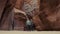 Hikers Hiking Along Sandy Riverbed In Deep Cave Slot Canyon With Curved Rocks