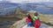 Hikers looking at view on mountain top summit on hiking travel vacation