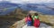 Hikers looking at view on mountain top summit on hiking travel vacation