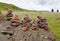 Hikers passing some cairns in a hilly landscape