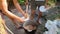 Hikers serving porridge cooked in metal bowler on campfire