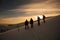 Hikers silhouette at dawn on Mount Ciucas in winter watching the sunset