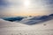 Hikers silhouette at dawn on Mount Ciucas in winter watching the sunset