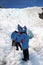 Hikers in single file ascending rugged icy slope at glacier exploration