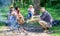 Hikers sit near campfire relaxing while wait roasting food. Hikers organized quick picnic to eat and relax. Hikers spend