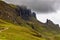 Hikers on a spectacular remote, rocky landscape with a low, moody sky Quiraing, Isle of Skye