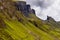 Hikers on a spectacular remote, rocky landscape with a low, moody sky Quiraing, Isle of Skye