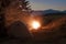 Hikers tent in mountains at evening with a bonfire with sparkles