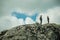 Hikers on top of rock formation with bushes