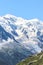 Hikers on the top of a rock overlooking amazing Mount Blanc, near Chamonix in Alps, France. Highest peak of French Alps and Europe