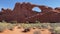 Hikers walk toward Skyline Arch along the trail in Arches National Park