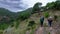 Hikers walking along a path in the Sierra de Almiijara and Tejeda with pine trees and a cloudy stormy sky