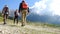 Hikers walking outdoors wearing hiker backpacks.