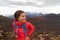 Hiking Asian woman in volcano landscape walking in Hawaii. Happy hiker on trek with backpack and red rain jacket