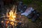 Hiking boots are drying near the fire in the forest