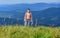 Hiking concept. Muscular tourist walk mountain hill. Power of nature. Man unbuttoned shirt stand top mountain landscape