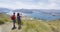 Hiking couple taking photo using phone on mountain top Roys Peak, New Zealand