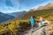 Hiking couple walking on trail at Routeburn Track during sunny day. Male and female hikers are tramping on Key Summit