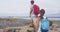 Hiking Couple Wearing Backpacks While Walking On Rocks At Shipwreck Beach