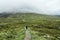 Hiking through dramatic and cloudy landscape  of Buachaille Etive Beag in the Scottish Highlands