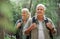Hiking, elderly couple and active seniors in a forest, happy and relax while walking in nature. Senior, backpacker and