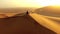 Hiking, exploring and adventure with a young man sitting on a sand dune in a hot, arid and barren desert landscape. A