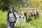 Hiking Friends Walking Amidst Plants In Forest