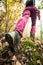 Hiking girl in a mountain. Low angle view of generic sports shoe and legs in a forest. Healthy fitness lifestyle outdoors