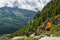 Hiking in the Italian Alps. Hiker with backpack, look at the panorama from above