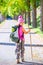 Hiking kid girl with walking stick and backpack in autumn