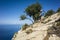 Hiking on Lycian way. Man with backpack walking down on rock slope high above Mediterranean sea on Lycian Way trail