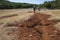 Hiking Lycian way. Man is walking on dry cracked red soil trail on stretch between Saribelen and Gokceoren, Trekking in Turkey