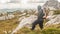 Hiking man with backpack on mountain ridge looking mountain peak