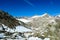 A hiking man crossing a snow field with scenic view on Hoher Sonnblick in High Tauern mountains in Carinthia, Salzburg, Austria,