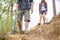 Hiking man and woman with backpack and trekking boots on the bright green moss passage trail in forest