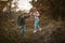 Hiking in nature. Young Man and Woman backpackers descend from the slope holding hands and holding hiking poles in their