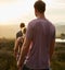 Hiking off into the sunset. Rearview shot of three young hikers on a mountain trail.