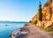 Hiking path along the sea with lonely cypress tree at sunset near Nafplio, Greece