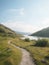 A hiking path through hills and a lake