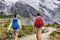 Hiking people walking on mountain trail trekking with backpacks. Hikers couple backpacking in nature, outdoor active