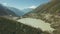 Hiking people walking on mountain trail with view of lake and snow peaks