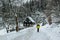 Hiking Person in yellow jacket. Beautiful rural wooden house in a small village in picturesque region of Bohemian Switzerland