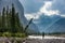 Hiking in the rain Woman Hiker crosses the Ghost River Trans Alta trail with Mt Aylmer in the background