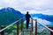 Hiking Rampestreken. Tourist man on the Rampestreken Viewpoin. Panoramic landscape Andalsnes city in Norway