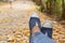 Hiking shoes young woman traveler sit down on summer park.focus on blue sneaker shoes and jeans on pathway. active activity