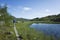 Hiking in Swedish Lapland. Man traveler trekking alone on wooden trail next to small mountain lake in Sweden